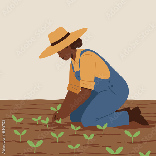 Black female farmer wearing a straw hat and overalls planting seedlings in a field of soil