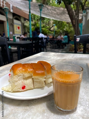 Indian chai with bun maska served at an outdoor cafe table