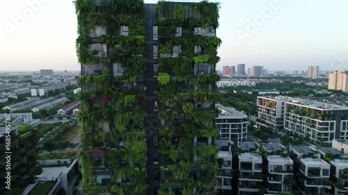 A building facade covered in lush greenery stands tall, offering a refreshing contrast to the surrounding urban environment and cityscape.