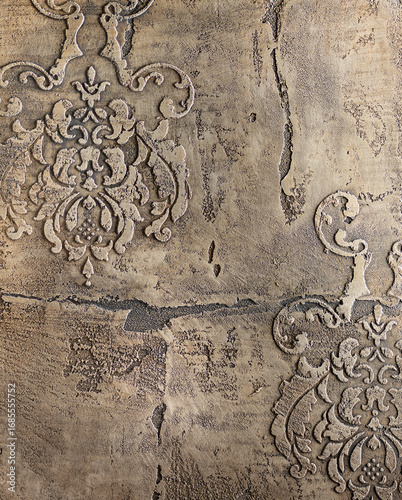 Textured wall featuring intricate vintage patterns in muted tones, showcasing a blend of elegance and rustic charm, perfect for interior design inspiration and artistic projects