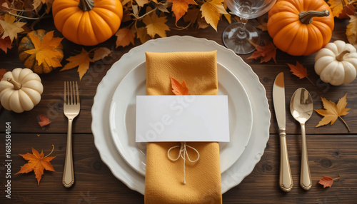 autumn dining table setting with white plate, golden fabric napkin, cutlery tied with rustic string, and blank place card