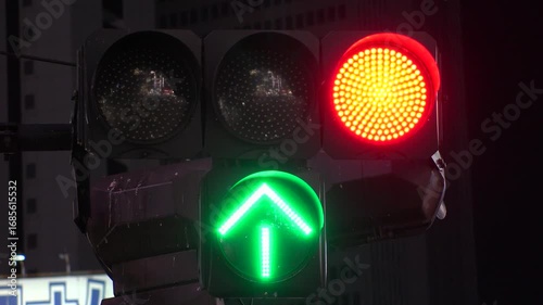 TOKYO, JAPAN - AUG 2025 : Close up shot of led traffic light at the street in night time. Green, yellow, red and arrow. Japanese traffic and transportation concept video. 4K time lapse shot.