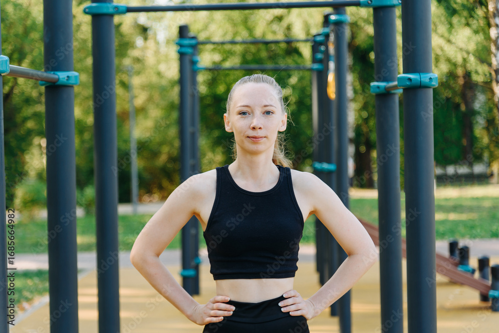 Obraz premium young slim athletic caucasian woman portrait, good sport shape, street sports ground outdoors in summer, beautiful redhead girl, black sportswear, healthy lifestyle concept