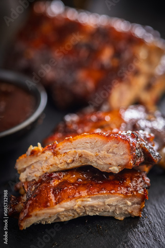 Pork BBQ glazed ribs on black table.