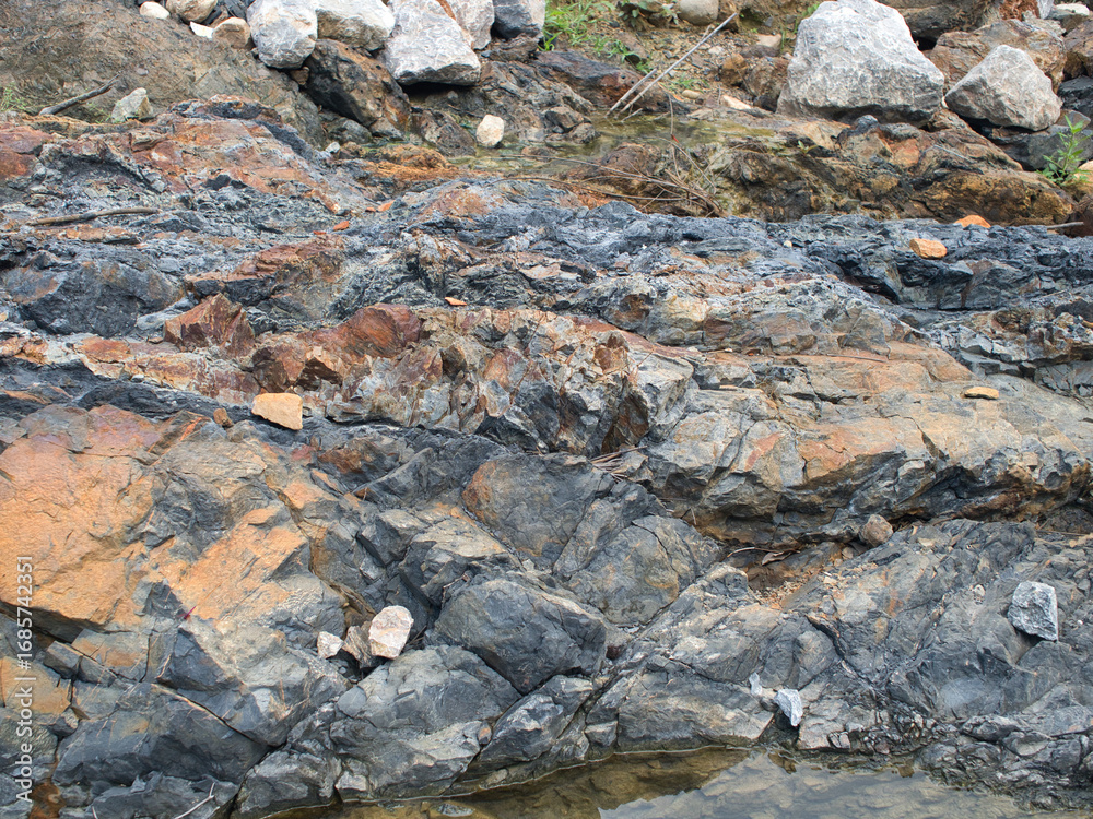 Fototapeta premium Black rocks from drilling in rivers and streams.