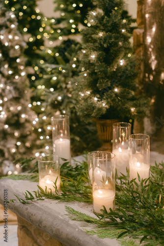 Elegant holiday decorations with glowing candles and evergreen accents at a festive indoor gathering