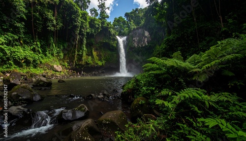 Lush waterfall cascading into a pool, surrounded by dense jungle