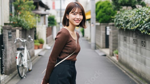 住宅街の路地で振り返りながら微笑むボブヘアの美人女性
