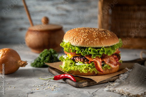 Homemade hamburger with bacon and chili pepper on the table