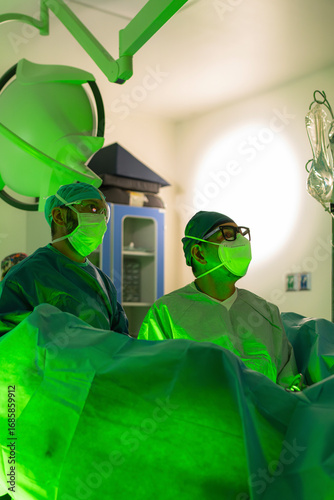 Two urologist surgeons performing laser surgery in operating room