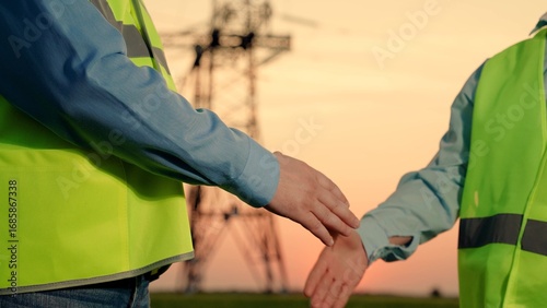 Businessmen handshake, partners. Teamwork engineers, partners shaking hands, good work. Team of power engineers construction workers, woman, man work together. Energy business, partners make deal