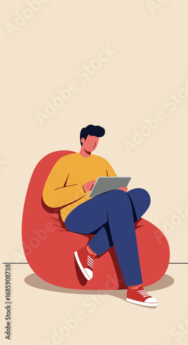 Young man relaxing on a bean bag chair, engrossed in his tablet, symbolizing modern comfort and digital connection.