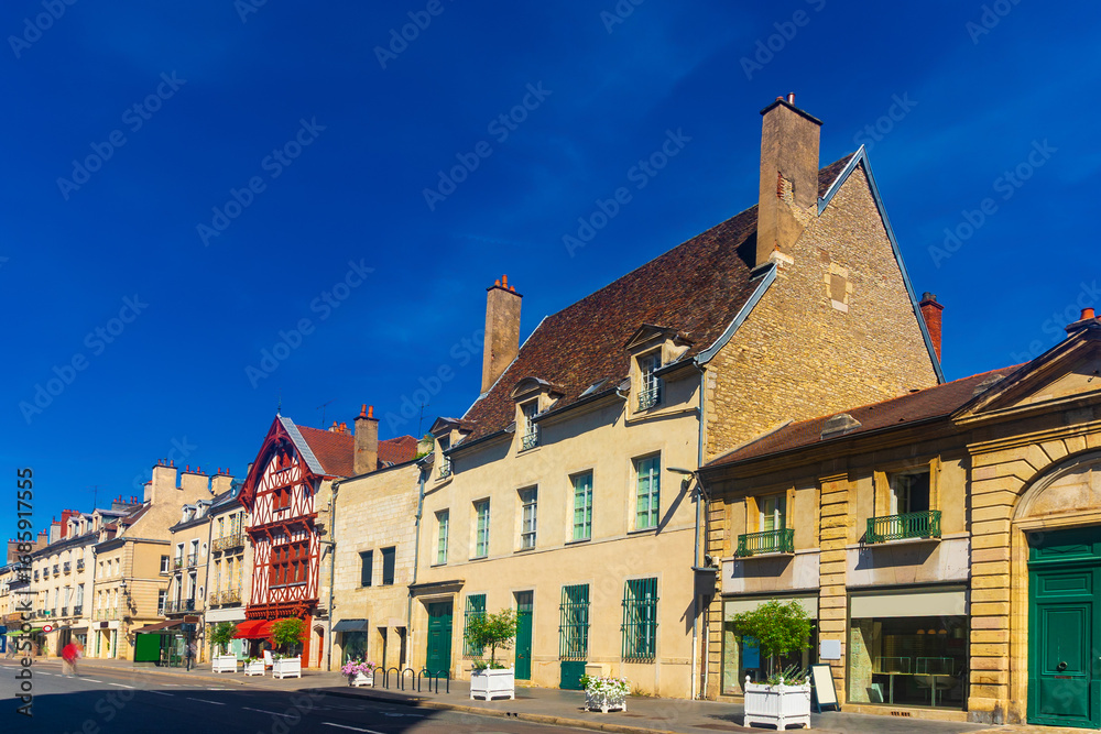 Naklejka premium Picturesque summer cityscape of Dijon overlooking narrow street with typical residential townhouses , France.