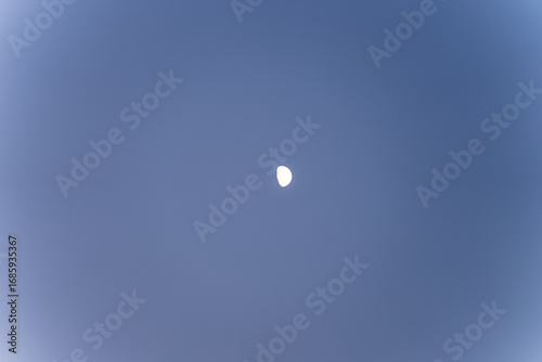 Moon in the evening sky over Cyprus. Astronomical landscape against the blue sky.
