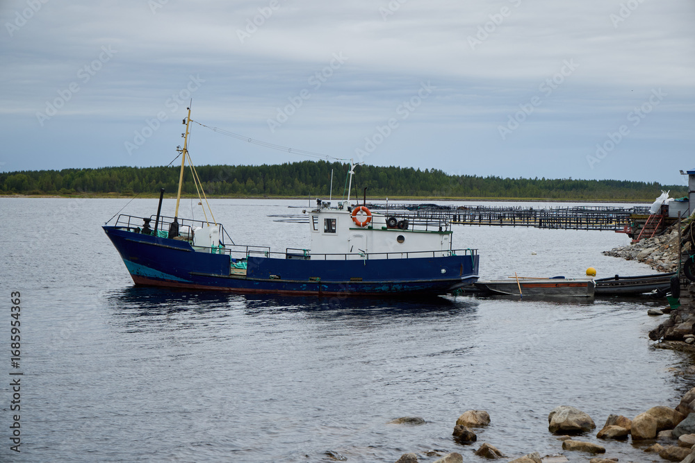 Fototapeta premium A Fishing Boat is peacefully moored at the dock on a lovely and calm day by the sea
