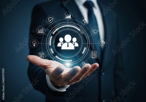 A person in a suit presenting a glowing, circular digital interface. At the center is an icon representing a team or customer base. This is surrounded by various business function icons such as securi