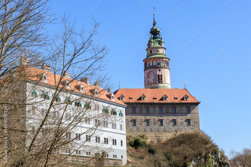 Naklejka premium Historic castle tower and building against blue sky in Cesky Krumlov