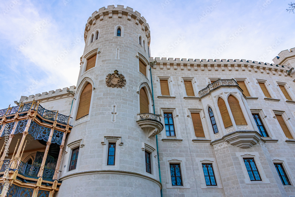 Fototapeta premium Historic european castle exterior with architectural details and blue sky backdrop