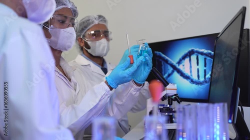 A team of geneticists collaborates on a gene sequencing analysis. The lead researcher points to a 3D model of a DNA helix, discussing specific loci with colleagues.