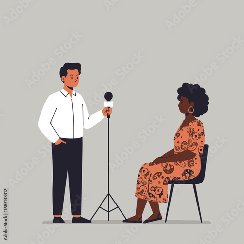 A man interviews a woman seated, with a microphone on a stand.