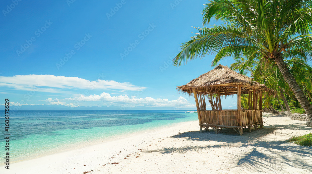 Fototapeta premium A tropical bamboo hut on a white sand beach with clear turquoise waters and palm trees.