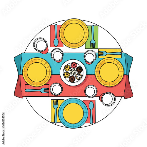 Overhead view of a round table setting with colorful plates, cutlery, glasses, and a dessert platter.