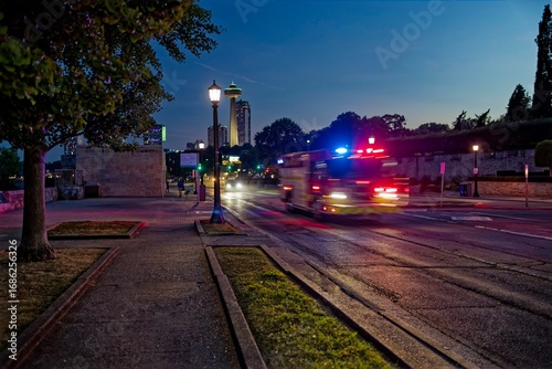 Fire truck with flashing lights speeding on a city street at night in Niagara Falls, Canada