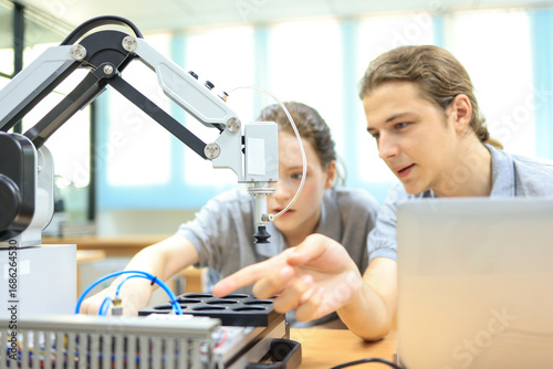 automation machine engineer student study and inspection control robot arm machine in university or factory workshop. AI robot technology are new innovation trend for manufacturing in industry