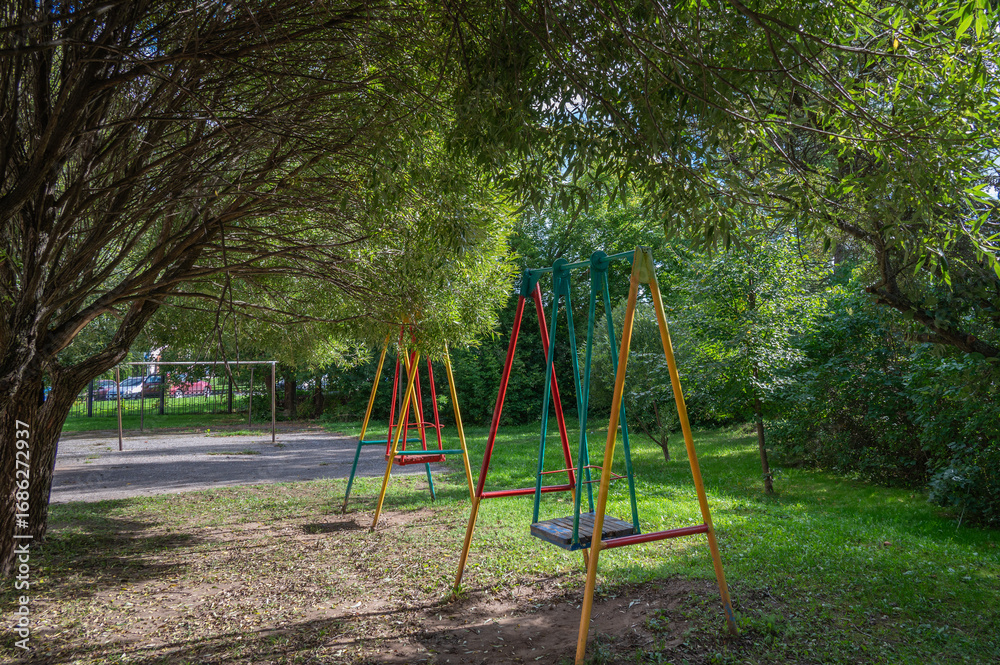 Fototapeta premium Empty swings in the autumn courtyard.