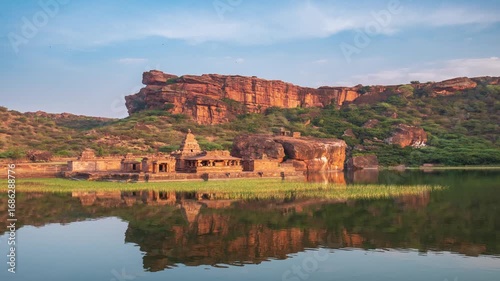 Time lapse: ancient Badami rock temple Karnataka India reflected in Agastya lake surrounded by sandstone cliffs symbolizing heritage spirituality culture serenity timelessness