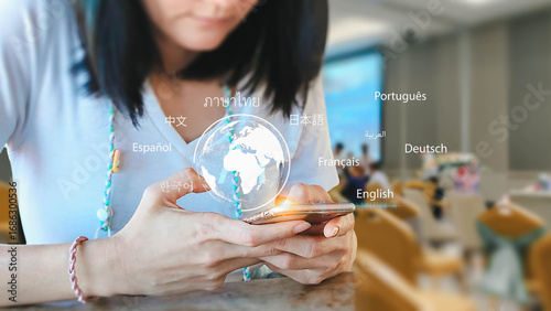 A woman uses her mobile phone for language translation. A digital globe and different languages are displayed above the screen, showing modern communication technology.