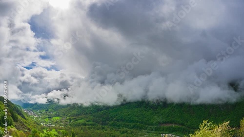 Time lapse: Alps Italy mountain forest ridge under vast sky with dramatic cumulus clouds, capturing grandeur of nature, scale of wilderness, essence of freedom and awe