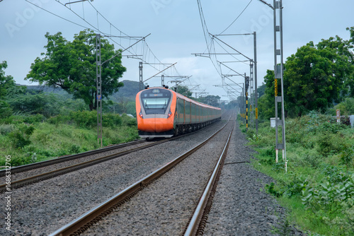 Saffron coloured Vande Bharat Express near Pune India. This is a made in India train set and also known as Train 18.