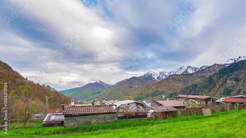Time lapse: Rustic village Varaita Valley Piedmont Italy with snow capped Alps in background under pastel sunset sky blending nature architecture serenity
