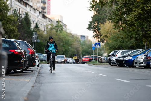 Wallpaper Mural Delivery man riding bicycle on city street delivering food Torontodigital.ca