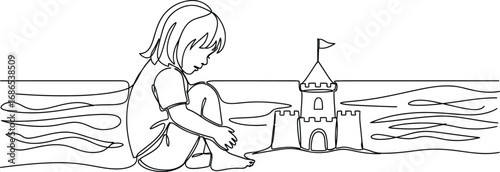 Child focused on building a sandcastle by the ocean waves.