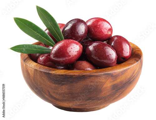 Deep red olives in a wooden bowl, with fresh leaves