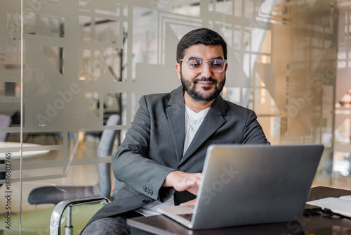 Canvas-taulu Professional man engaged with laptop in a modern office environment enhancing pr