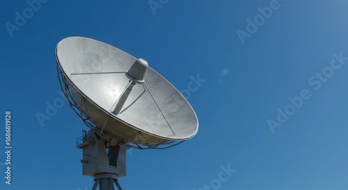 Large satellite dish against a clear blue sky communication technology.