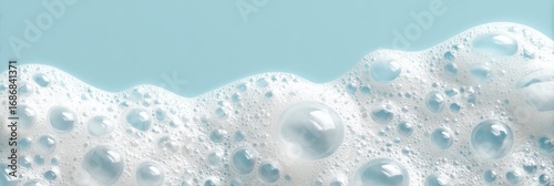 Close-up of white soap foam with bubbles on blue background, abstract panoramic texture. Concept of hygiene, freshness, cleaning, purity, sanitation, detergent, skincare, wellness, cosmetic advertisin
