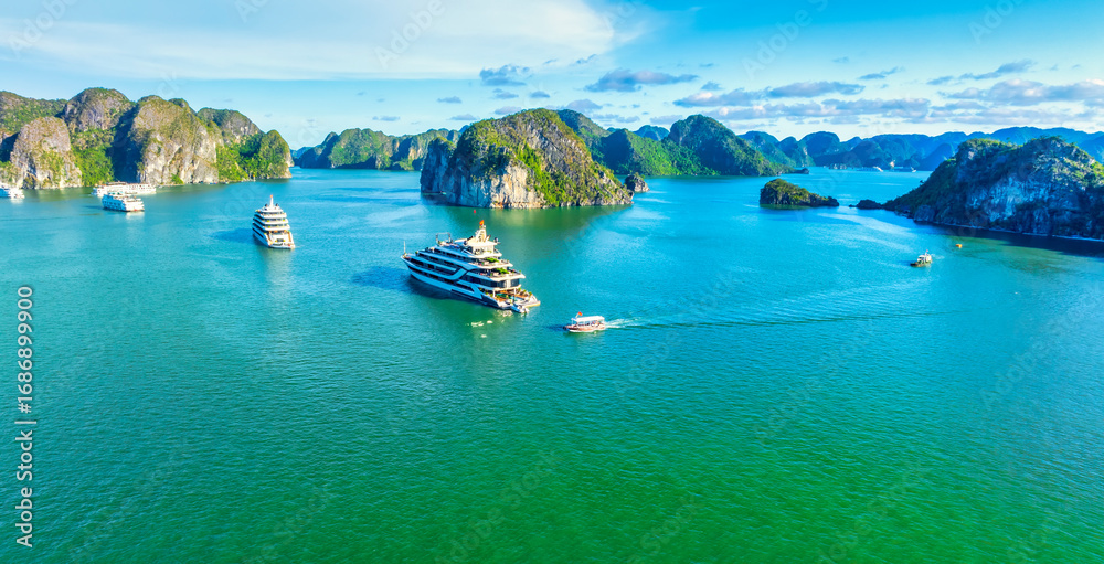 Naklejka premium Aerial view of landscape Halong Bay, Vietnam view from adove. Tourist cruise ship floating among limestone rocks. This is the UNESCO World Heritage Site, it is a beautiful natural wonder in northern V
