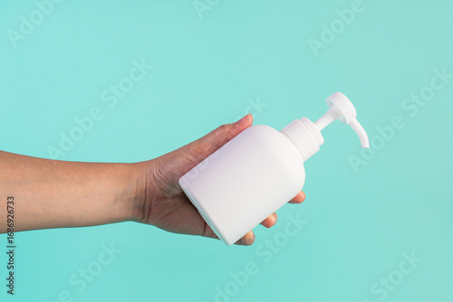 White pump product bottle in hand on blue background