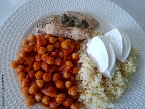 Healthy lunch meal. Chickpea. Chicken fillet, bulgur and yogurt on the plate.