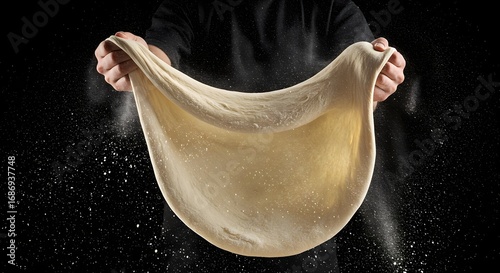 A pizza dough being stretched