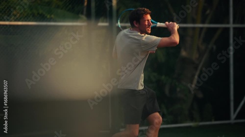 An athletic man plays an active game of tennis on an outdoor court, demonstrating fitness and skill