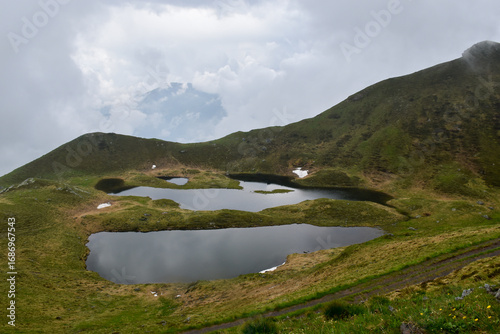 An aerial view of the Zoufplan lakes in Carnia. The image captures the beauty and tranquility of these alpine lakes, framed by the green landscape.