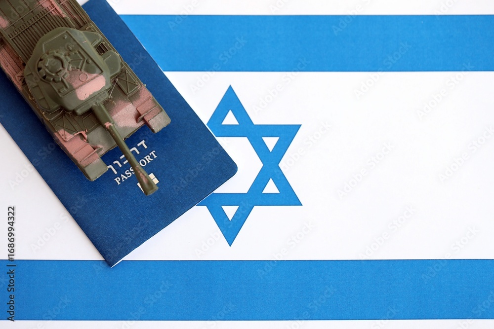 Obraz premium Israel passport and toy tank on flag. The current Israel passport and tank lies on flag close up