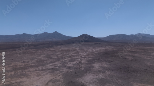 Desert Track Through Volcanic Hills Under Clear Sky – Remote Arid Landscape