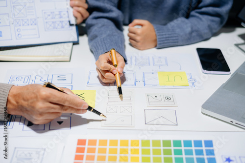 Creative UX UI team designing website wireframes, templates, and color systems with digital tools and real people in a tech office environment.