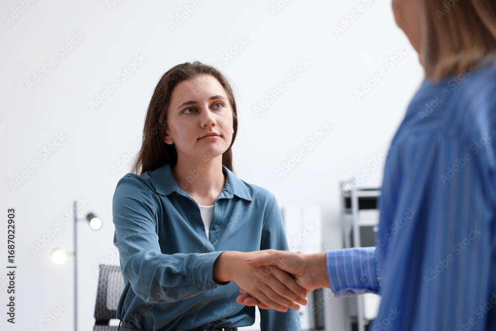 Obraz premium Cooperation and teamwork. Women shaking hands in office